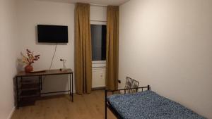 a bedroom with a bed and a table and a television at An der Stadtmauer in Mayen