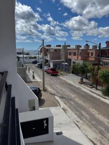 einen Balkon mit Blick auf eine Straße mit Gebäuden in der Unterkunft Amaneceres patagónico in Puerto Madryn