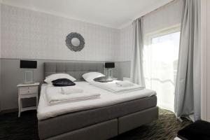 sypialnia z dużym białym łóżkiem i oknem w obiekcie Apartament Glamour - 5 Mórz - Basen - SPA - Sauna w Sianożętach +32 zdjęcia