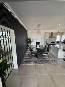 een keuken en woonkamer met een tafel en stoelen bij Tinchley Havanna, Luxury 3 Bedroom home in Kaapstad