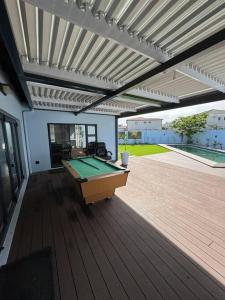 een terras met een pooltafel op een dek bij Tinchley Havanna, Luxury 3 Bedroom home in Kaapstad