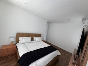 een slaapkamer met een bed en een flatscreen-tv bij Tinchley Havanna, Luxury 3 Bedroom home in Kaapstad +23 foto's