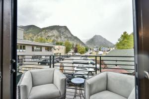 two chairs on a balcony with a view of a street at Frisco Gold Townhome: Downtown Luxury, Great Views in Frisco