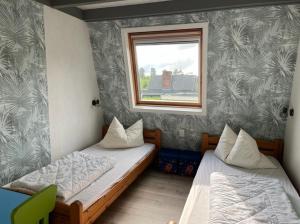 two beds in a room with a window at Piratennest Breskens in Breskens
