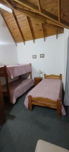 two beds in a room with wooden ceilings at Duplex 7 Lunas in Villa Gesell