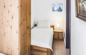 a small bedroom with a bed and a wooden door at Doppelhaushälfte Klink in Klink