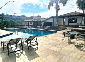 a patio with a pool and chairs and a table at Casa em Condomínio em Geribá Alto Padrão in Búzios