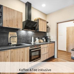 a kitchen with wooden cabinets and a stove at Apartmenthaus Schlag in Naumburg