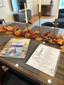 a table with two candles and a magazine on it at Saugerties Waterfront Getaway in Saugerties