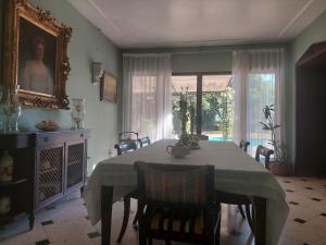 una sala da pranzo con tavolo, sedie e finestra di Residencia Casa del Roble 1 a Cuernavaca