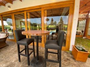 einen Holztisch und Stühle in einem Zimmer mit Fenstern in der Unterkunft Casa de campo en Hacienda San Andres in San Andrés
