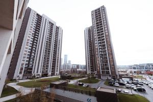 two tall buildings with cars parked in a parking lot at inJoy in Belgrade