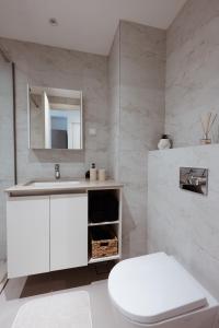 a bathroom with a white toilet and a sink at inJoy in Belgrade