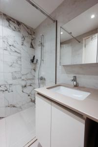 a white bathroom with a sink and a shower at inJoy in Belgrade +6 photos
