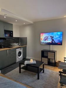 a living room with a tv on the wall at Studio Buttes Chaumont refait à neuf in Paris