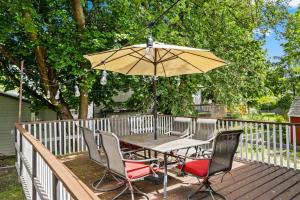 a table and chairs with an umbrella on a deck at Hot Tub and Spacious Backyard Close to Lake! in Coeur d'Alene