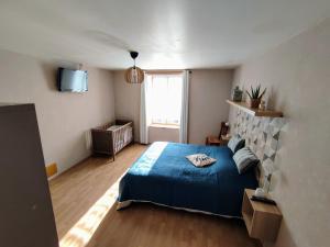 a bedroom with a blue bed and a window at Gîte confortable avec cheminée et parking, proche Verdun - FR-1-585-159 in Dompcevrin +23 photos