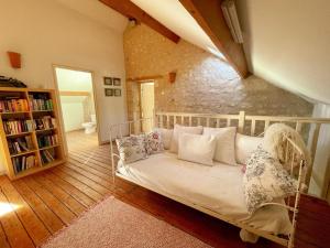 a living room with a white couch and a book shelf at Gîte en Touraine avec piscine privée, spa et WiFi - FR-1-381-601 in Cussay