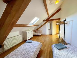 two beds in a attic room with wooden beams at Gîte en Touraine avec piscine privée, spa et WiFi - FR-1-381-601 in Cussay