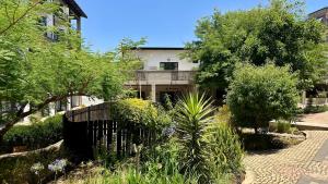 a house with a fence in front of a garden at City Living Apartment 119 - Private Balcony, Washing Machine & Fast WiFi in Johannesburg +47 photos