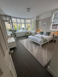 a bedroom with a bed in a room with windows at Woodfalls Luxury Getaway in Bournemouth