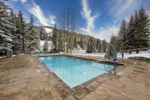 a swimming pool in the middle of a snow covered yard at Lion Square Lodge South 255 & 257 in Vail