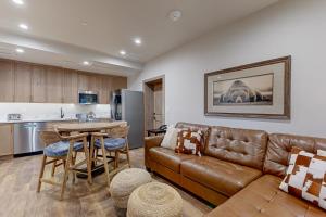a living room with a brown leather couch and a table at Lion Square Lodge South 255 & 257 in Vail