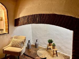 a chair and a table in a room with a window at Casa do Montado in Portel