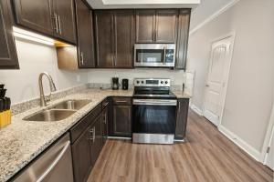 a kitchen with wooden cabinets and a stove and a sink at Biltmore Luxury 1513 #5 Townhomes L 2bd 2 Bth in Clarksville