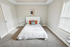 a bedroom with a white bed in a white room at Properties By Preston I L 2bd2bth Townhome in Clarksville