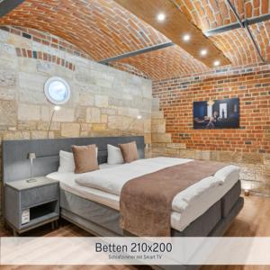 a bedroom with a large bed in a brick wall at Apartmenthaus Schlag in Naumburg +87 photos