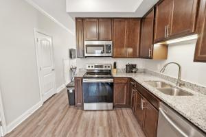 a kitchen with wooden cabinets and stainless steel appliances at Biltmore Luxury 1517 #6 Townhomes L 2bd 2 Bth in Clarksville