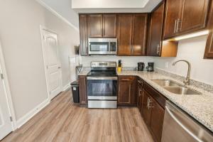 a kitchen with wooden cabinets and stainless steel appliances at Biltmore Luxury 1517 #2 Townhomes L 2bd 2 Bth in Clarksville