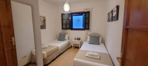 a small room with two beds and a mirror at Sabbia Suites Marazul in Playa Honda