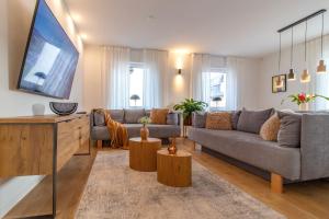 a living room with a couch and a tv at Stilvolles City-Apartment I WLAN l Küche I Zentral I 8P in Schwarzenberg