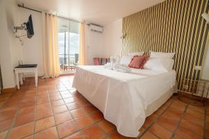 une chambre avec un grand lit blanc et une table dans l'établissement Appartements avec vue mer à Tartane, à La Trinité