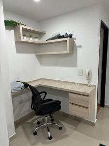 a computer desk with a black chair in a room at 302 Apartamento in Tunja