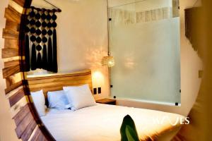 a bedroom with a white bed with a wooden headboard at Natural Lighted Boho Chic Studio with Private Pool by Waves in Tulum