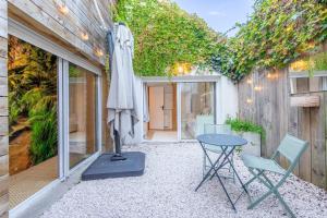 a patio with a table and a umbrella and chairs at Patio - 2min gare - Local velos motos - clim in Bordeaux