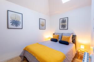 a bedroom with a bed with a yellow blanket at Patio - 2min gare - Local velos motos - clim in Bordeaux