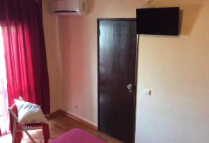 a wooden door in a room with a red curtain at Guesthouse RSA by Umbral in Almancil
