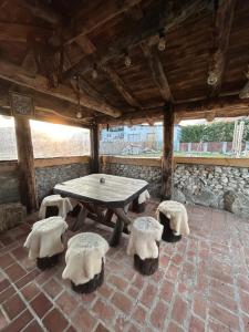 a picnic table and chairs in a room with a stone wall at Pensiunea Lorena in Bran