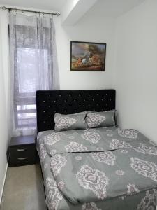 ein Schlafzimmer mit einem Bett und einem Bild an der Wand in der Unterkunft Apartman Mijatović Divčibare in Divčibare