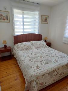 a bedroom with a bed with a quilt on it at Casa cerro Tacna Maitencillo in Maitencillo