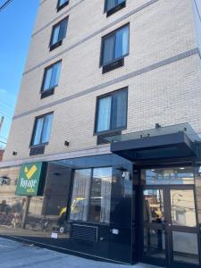 a building with a store front with its door open at Voyage Hotel in Long Island City