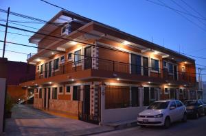 a house with a car parked in front of it at Terracota Corner Rooms in Campeche