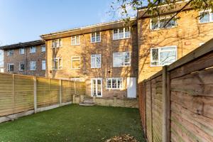 a brick building with a fence and a yard at Purley House-Sleeps 8-Near Gatwick-Games Room in Purley
