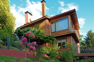 a wooden house with flowers in front of it at Mirabosque aparment Ejecutivos 8 in Osorno