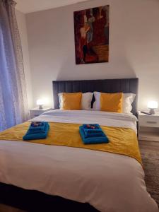 een slaapkamer met een bed met twee blauwe handdoeken erop bij Sophia Home 2 in Braşov