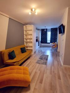 een woonkamer met een bank en een eetkamer bij Sophia Home 2 in Braşov